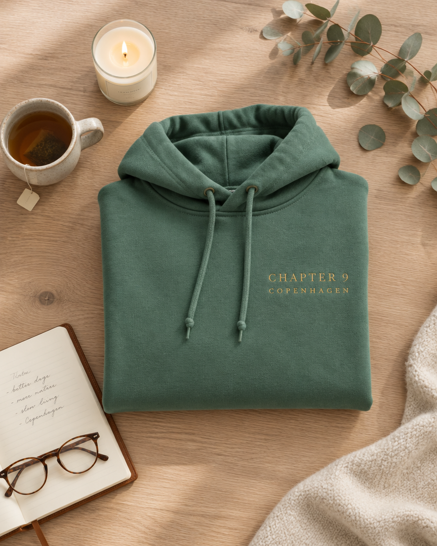 Folded sage green lounge hoodie with gold CHAPTER 9 COPENHAGEN embroidery, candle and tea